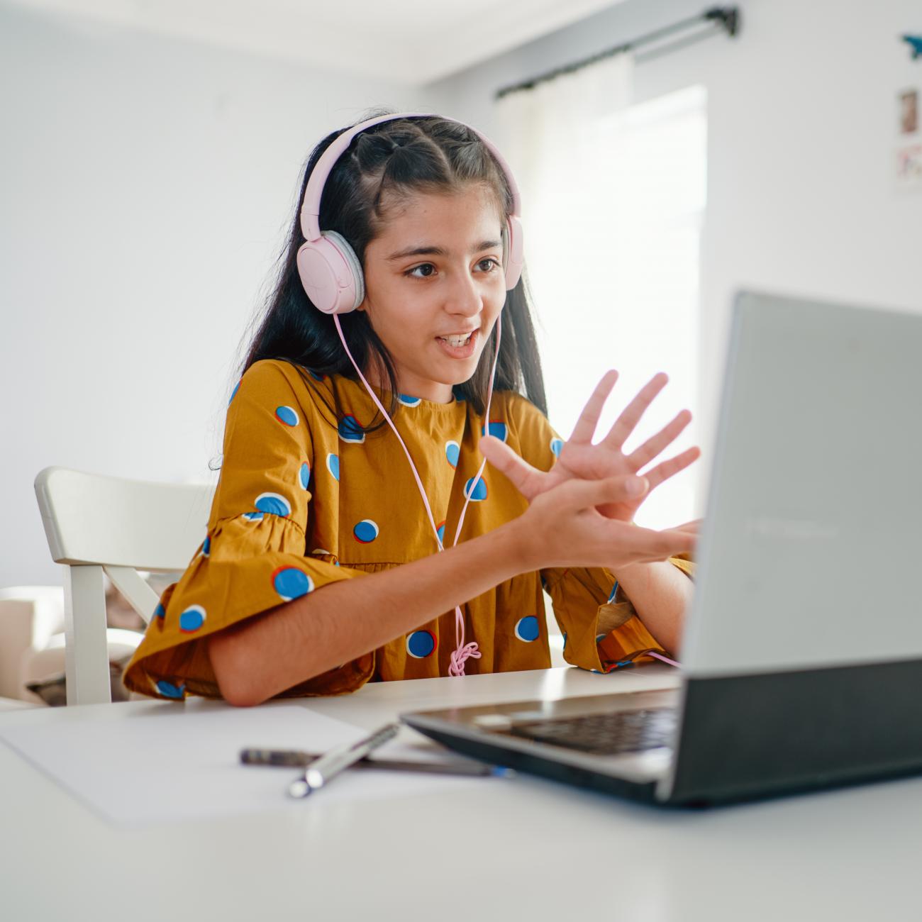 Student on their computer with headphones on.